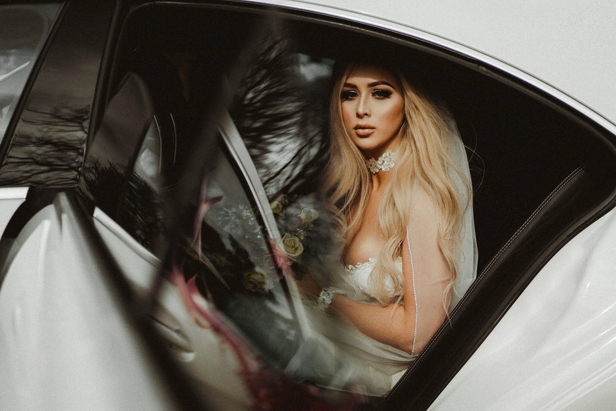 A photo of a bide in her wedding car| Wedding photographers and videographers