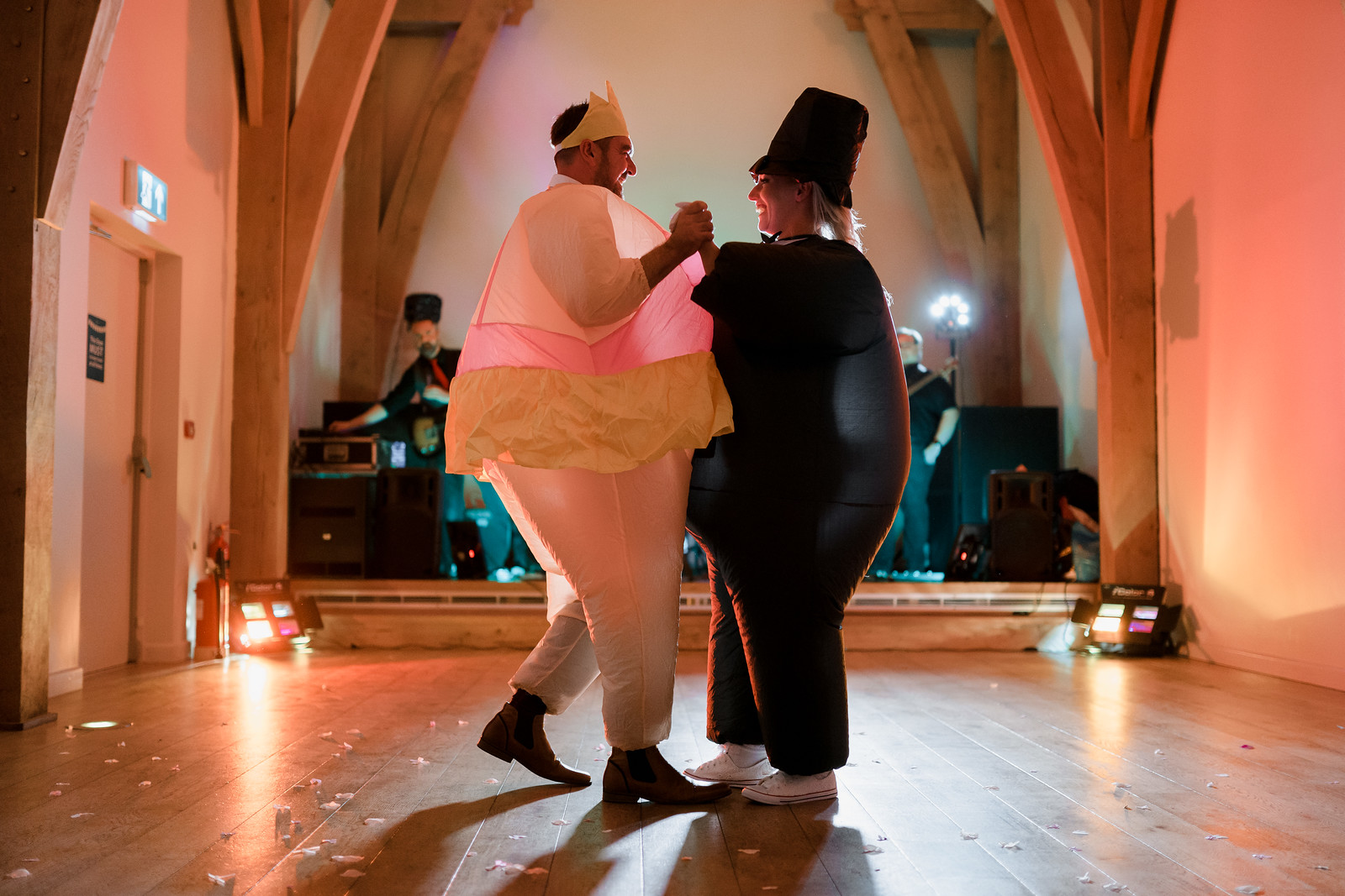 Bride and groom dancing in inflatable costumes - The Mill Barns